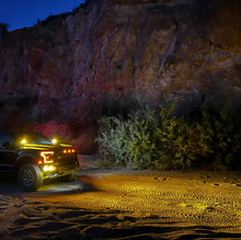 Load image into Gallery viewer, NACHO Quatro Off-Road lights illuminating a trail in the wilderness.