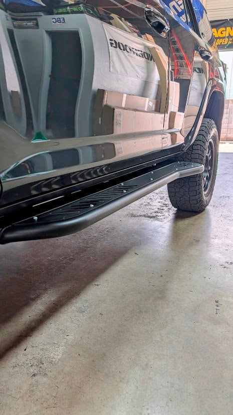 Action shot of a 4Runner equipped with D2 Off-Road 2010-2024 Toyota 4Runner Rock Sliders - Heavy-Duty Bolt-On navigating rough terrain.