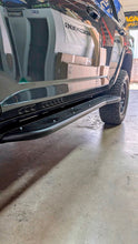 Load image into Gallery viewer, Action shot of a 4Runner equipped with D2 Off-Road 2010-2024 Toyota 4Runner Rock Sliders - Heavy-Duty Bolt-On navigating rough terrain.