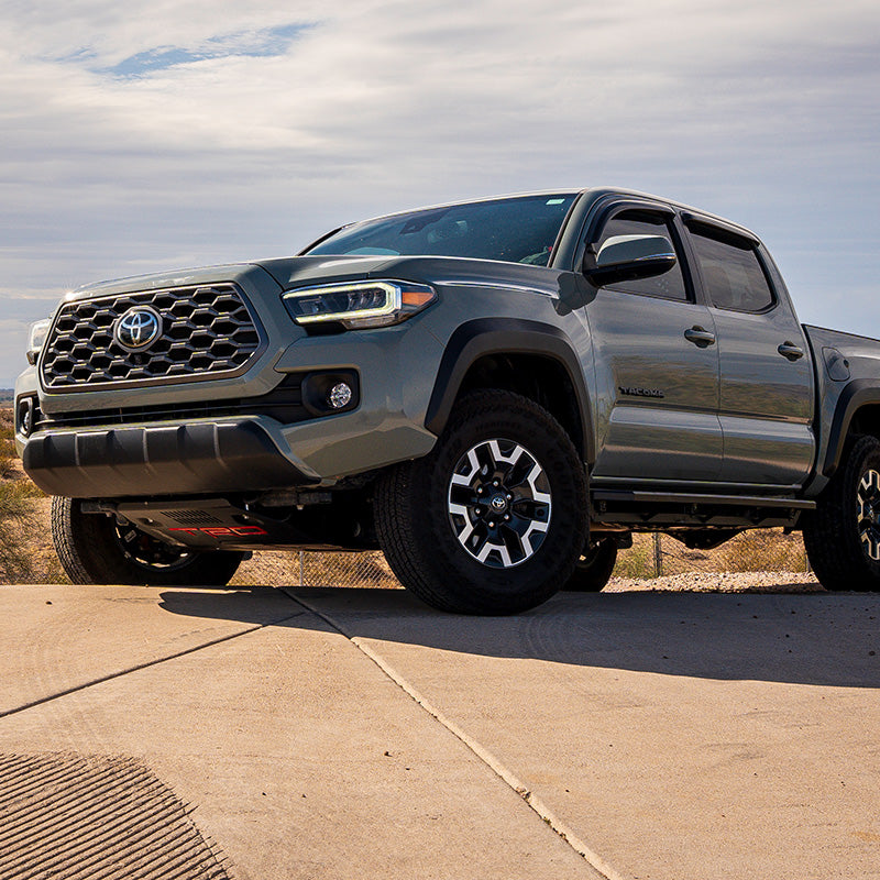 White light option of the TOYOTA SAE PLUG N PLAY FOG KIT shining bright on a Tacoma.